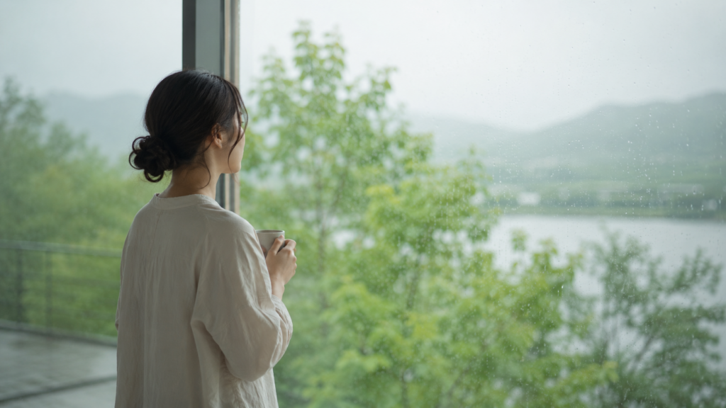 コーヒー片手に景色を見る女性